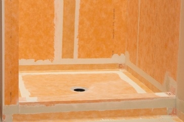 Leak from corner of shower pan behind and below pan