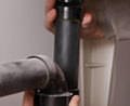 Plumber holding pvc pipes under sink