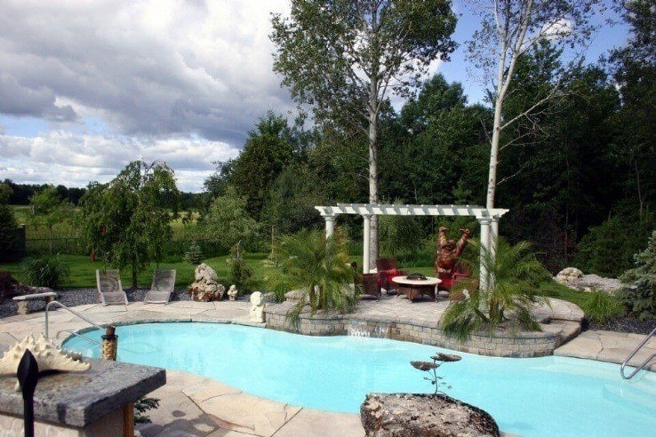 Fibreglass pool with flagstone border and interlocking patio